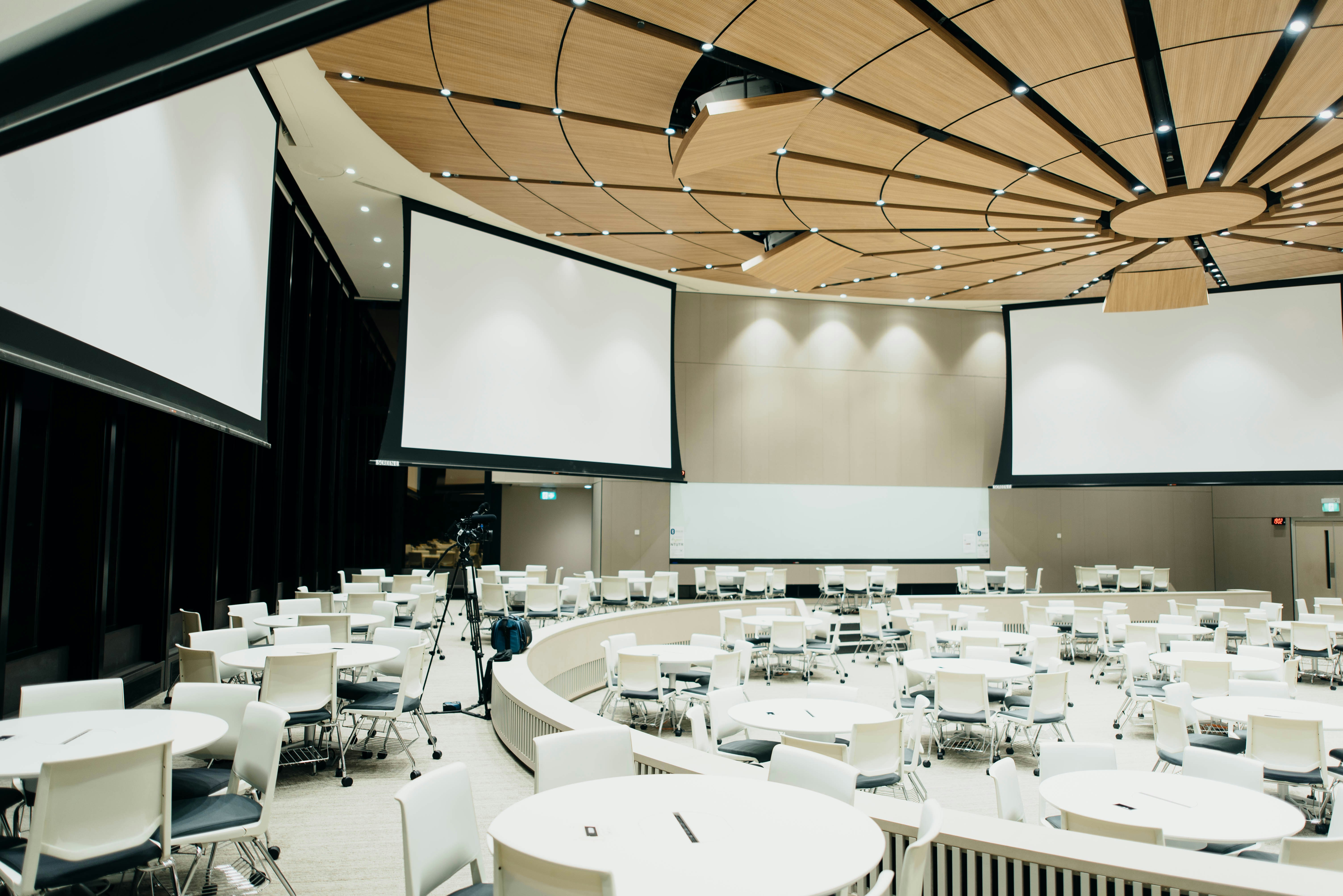 Conference room with curved rows of seating and projection screens